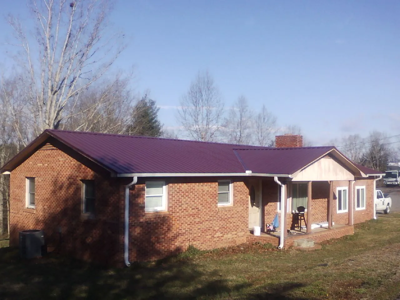 Burgundy metal roof on a brick ranch home with a new addition in Naval Air Station Jrb