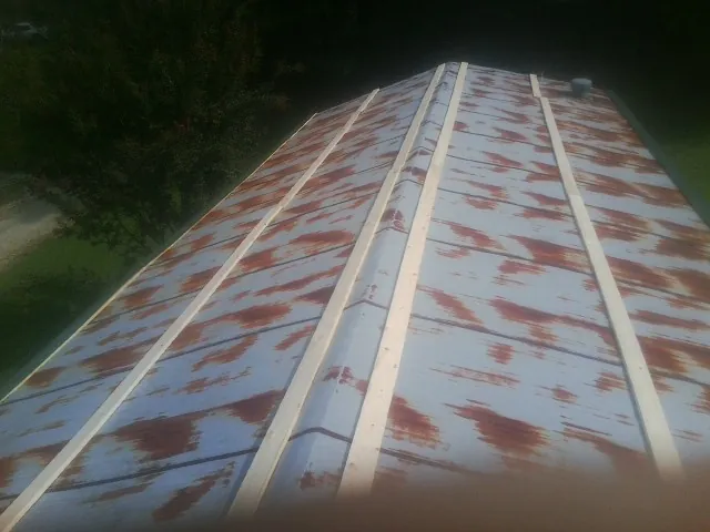 Rusted metal roof panels with new wood purlins before replacement — Storm Damage Roof Repair in Naval Air Station Jrb by Roofing Brothers