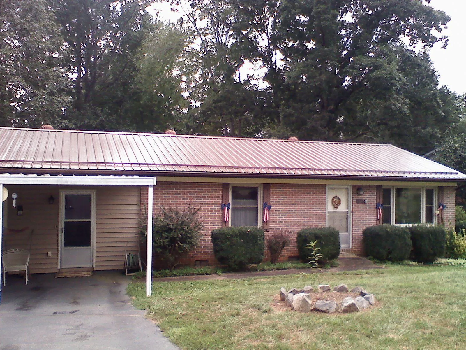 Bronze metal roof and carport on a brick ranch home — Roof Repair work by our crew in Naval Air Station Jrb